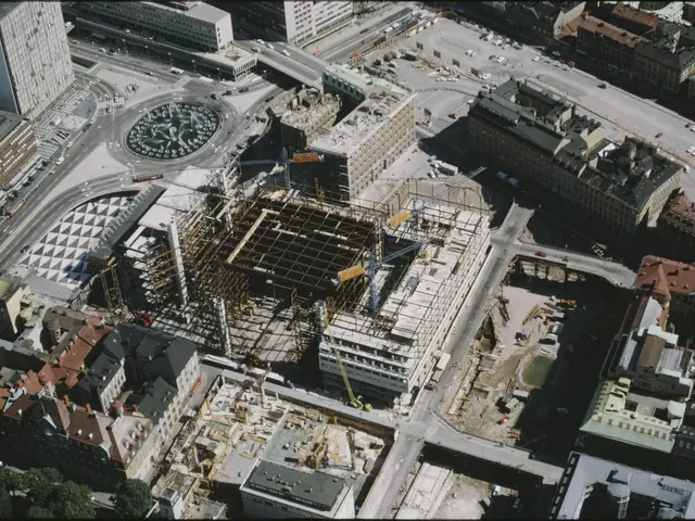 The image shows an aerial view of a bustling city with a large building under construction in the...