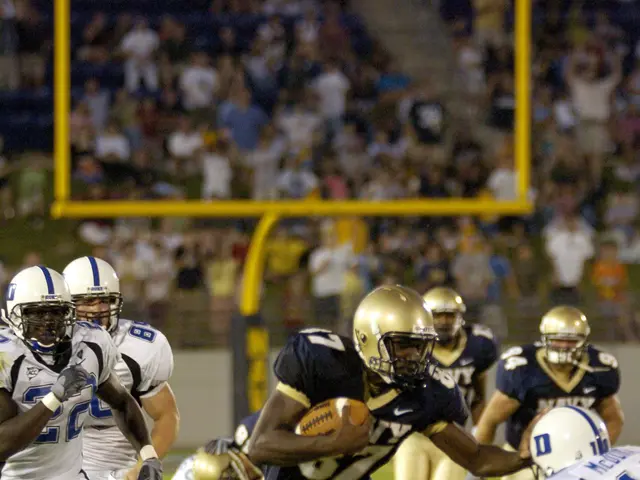 The image shows a football player running with the ball during a game, surrounded by a group of...