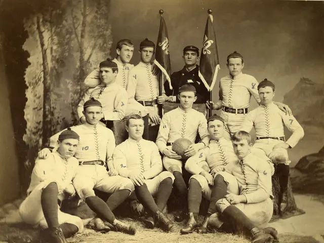 The image shows an old black and white photo of a baseball team, with some of the players sitting...