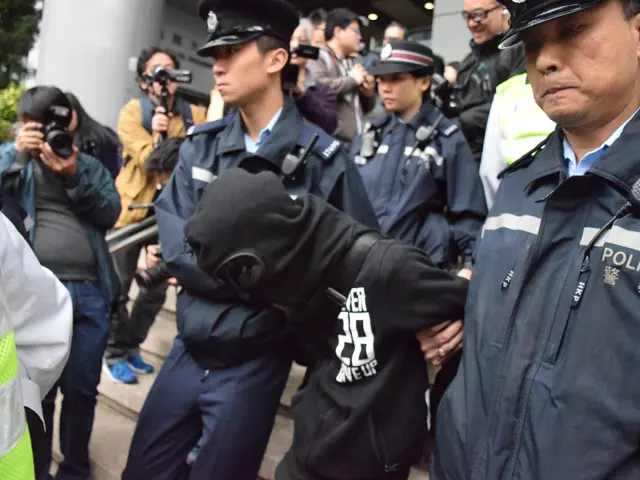 The image shows a group of police officers standing next to each other in front of a crowd of...