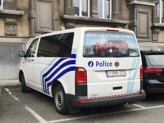 The image shows a police van parked in a parking lot next to a building with windows. The van has a...