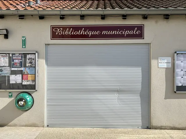 The image shows a building with a sign that reads "Bibliothèque municipale" on the side of it....