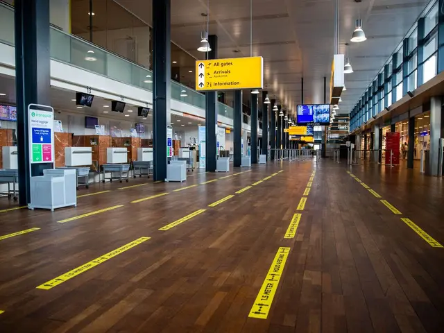 The image shows a long hallway in an airport with yellow caution tape on the floor. There are...
