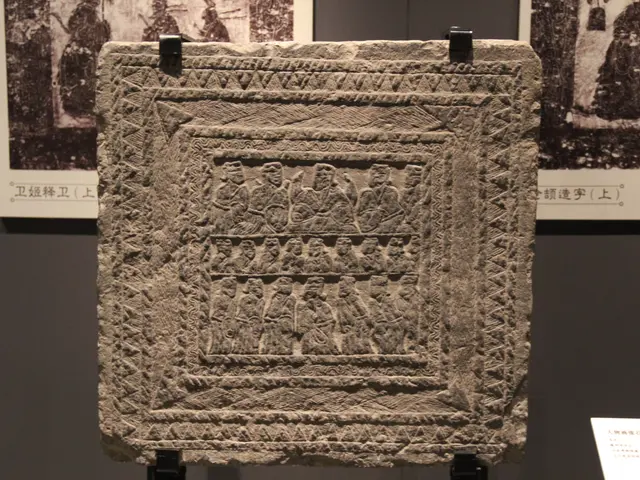 The image shows a stone plaque on display in a museum, with carvings on it and photo frames...