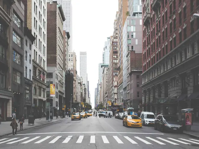 The image shows a bustling city street filled with lots of traffic and tall buildings. There are...