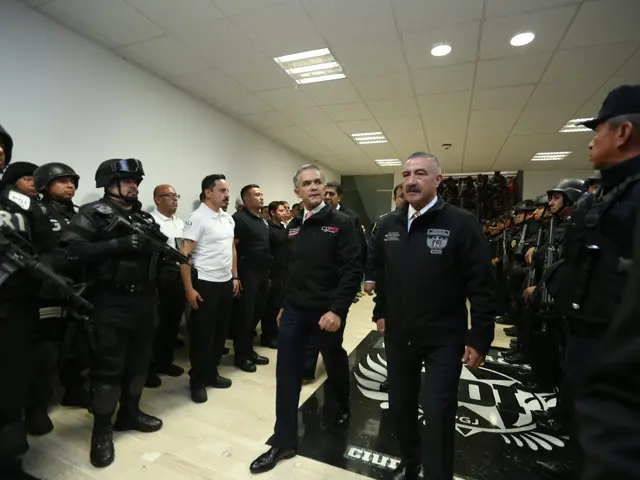 The image shows a group of men standing next to each other in front of a line of police officers...