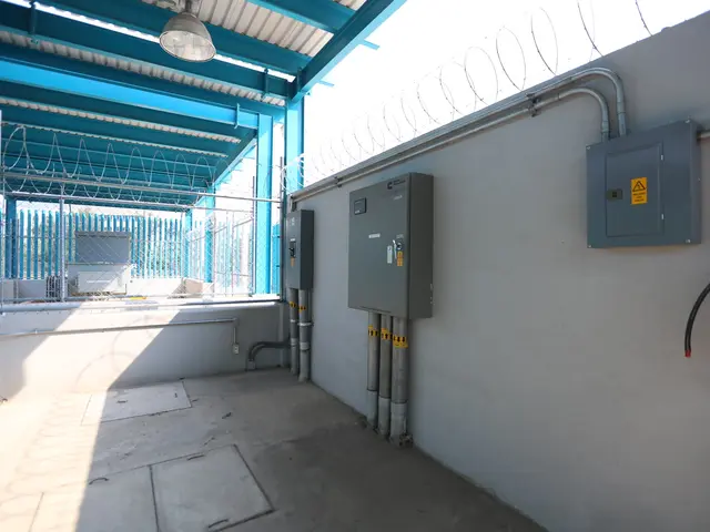 The image shows a room with a fire extinguisher on the right side, electrical boxes and pipes on...