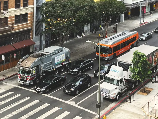 The image shows a city street filled with lots of traffic, including cars, buses, and trucks. There...
